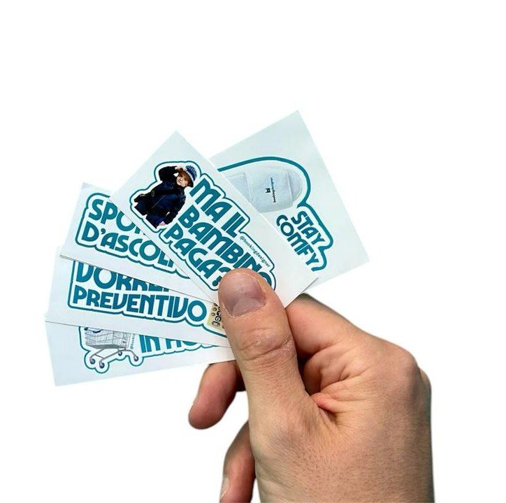Una mano che tiene a ventaglio gli adesivi Booking Designer: Sportello d’ascolto, Ma il bambino paga?, Vorrei un preventivo, Stay comfy, Colazione in hotel